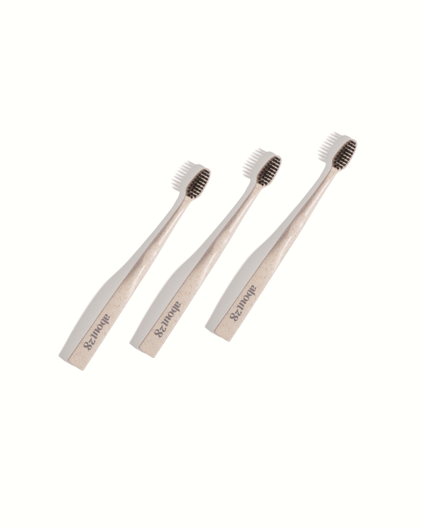 three stylish stone coloured toothbrushes with black bristles